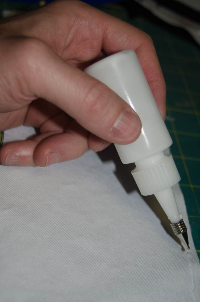 Applying a small bead of glue to the fabric